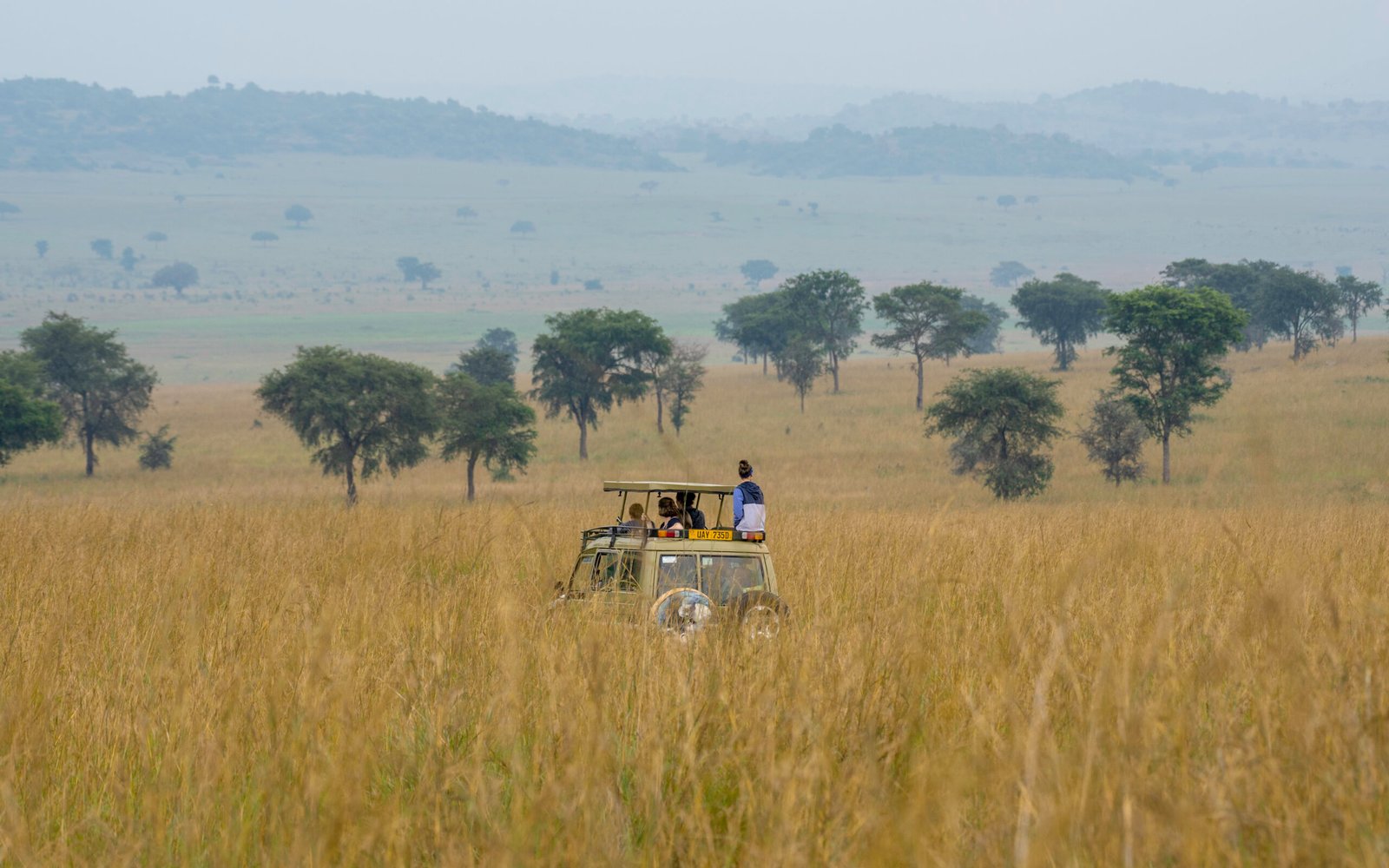 Safari vehicle exploring the golden savannah plains of Kidepo Valley National Park, Uganda.